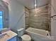 Bright bathroom featuring a tub with tiled wall, a toilet, and a vanity with modern fixtures at 2035 Clarksdale Dr # 33, Charlotte, NC 28206