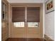 Hallway with hardwood floors and double doors leading outside with natural woven shades at 2112 Floral Ave, Charlotte, NC 28203