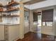 This kitchen features wooden floating shelves, granite countertops, and neutral colored cabinets at 2112 Floral Ave, Charlotte, NC 28203