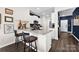 Open kitchen with bar seating, granite countertops, stainless steel appliances, and dark wood flooring at 2324 Lanza Dr, Charlotte, NC 28215