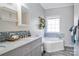 Bathroom featuring a double sink vanity with granite countertop, a blue backsplash, and soaking tub at 2864 Sweeping Pine Ln, Denver, NC 28037