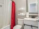 Bathroom featuring red shower curtain, white vanity, decorative mirror and tile backsplash at 2864 Sweeping Pine Ln, Denver, NC 28037