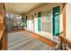 Covered front porch with blue outdoor rug, table and chairs, and turquoise shutters at 2864 Sweeping Pine Ln, Denver, NC 28037