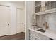 Stylish bar area with sink, marble backsplash, wine storage and brass faucet at 314 Royal Crescent Ln, Waxhaw, NC 28173