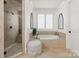 Bright bathroom featuring soaking tub, walk-in shower and shuttered windows at 314 Royal Crescent Ln, Waxhaw, NC 28173