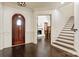 View of the foyer with a dark wood door, hardwood floors, and staircase with white risers at 314 Royal Crescent Ln, Waxhaw, NC 28173