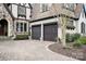 Charming home showcasing a stone and stucco exterior with a brick driveway and two-car garage at 314 Royal Crescent Ln, Waxhaw, NC 28173