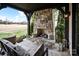 Covered patio with a stone fireplace, comfortable seating, and a view of the manicured lawn at 314 Royal Crescent Ln, Waxhaw, NC 28173