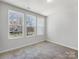 Bright bedroom with three windows bringing in natural light and a neutral color palette at 3215 Isenhour St, Charlotte, NC 28206