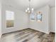 Bright dining area featuring wood-look floors, a stylish chandelier, and ample natural light from large windows at 3215 Isenhour St, Charlotte, NC 28206