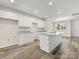 Modern kitchen featuring white cabinets, granite countertops, stainless steel sink, and wood-look floors at 3215 Isenhour St, Charlotte, NC 28206