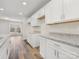 Modern kitchen featuring white cabinets, granite countertops, stainless steel sink, and wood-look floors at 3215 Isenhour St, Charlotte, NC 28206