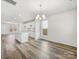 Open concept living space with wood-look floors, a modern light fixture, and abundant natural light at 3215 Isenhour St, Charlotte, NC 28206