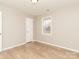 A light filled bedroom featuring wood floors, neutral walls and a window offering an outdoor view at 417 Columbus Ln, Monroe, NC 28110