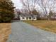 Inviting single-story home with gravel driveway, well-maintained lawn, and classic curb appeal at 417 Columbus Ln, Monroe, NC 28110