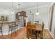 Bright dining area adjacent to kitchen, featuring bar seating, wooden dining table, and views to backyard at 4321 Rolling Acres Rd, Charlotte, NC 28213