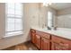 Bathroom featuring wood cabinets, large mirror, a window, and decorative accents at 5000 Tulip Ln, Matthews, NC 28104