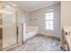This bathroom features a tile shower and separate tub, with a large window to bring in light at 5000 Tulip Ln, Matthews, NC 28104