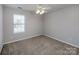 Bedroom with neutral carpet, a ceiling fan, and a window providing natural light at 5000 Tulip Ln, Matthews, NC 28104