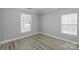 Serene bedroom featuring light gray vinyl floors, crisp white trim, and dual windows for natural light at 5000 Tulip Ln, Matthews, NC 28104