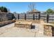 Stone fire pit in a fenced backyard with mature landscaping at 5000 Tulip Ln, Matthews, NC 28104
