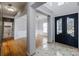 Grand foyer with hardwood and marble flooring, decorative pillars, chandelier, and black double door entry at 5000 Tulip Ln, Matthews, NC 28104