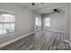 Open-plan living room with grey floors, white trim, modern ceiling fans, and abundant natural light at 5000 Tulip Ln, Matthews, NC 28104