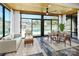Bright sun room with wood ceiling, hardwood floors, and walls of glass overlooking an outdoor pool area at 5000 Tulip Ln, Matthews, NC 28104