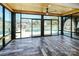 Bright sun room with wood ceiling, hardwood floors, and walls of glass overlooking an outdoor pool area at 5000 Tulip Ln, Matthews, NC 28104