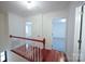 Hallway featuring hardwood floors, white railings, and bright lighting at 5925 Carmel Station Ave, Charlotte, NC 28226