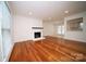 Spacious living room with hardwood floors, a white brick fireplace, and lots of natural light at 5925 Carmel Station Ave, Charlotte, NC 28226