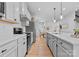 Bright kitchen boasts stainless steel appliances, white cabinets, and a large island with pendant lighting at 6231 Ashton Park Dr, Denver, NC 28037