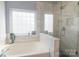 Bright bathroom featuring a soaking tub and glass enclosed shower at 7001 Conifer Cir, Indian Trail, NC 28079