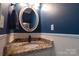 Elegant powder room featuring granite countertops, decorative mirror, and stylish fixtures at 7001 Conifer Cir, Indian Trail, NC 28079