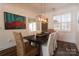 Dining room featuring modern lighting, a dark wood table, and views of colorful artwork at 7001 Conifer Cir, Indian Trail, NC 28079