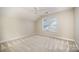 This bright bedroom features neutral walls, a large window, and carpeted floors at 7037 Ladys Secret Dr, Indian Trail, NC 28079