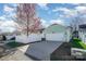 Charming home featuring a two-car garage, a well-manicured lawn, and mature trees under a blue sky at 7037 Ladys Secret Dr, Indian Trail, NC 28079