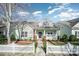 Charming one-story home with a welcoming front porch, a white picket fence, and beautiful landscaping at 7037 Ladys Secret Dr, Indian Trail, NC 28079