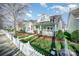 Street view of attractive homes with well-kept lawns and charming picket fences on a sunny day at 7037 Ladys Secret Dr, Indian Trail, NC 28079