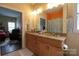 Bathroom featuring double sinks, a walk-in shower, and warm lighting at 822 Wisteria Way, Salisbury, NC 28146