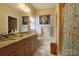 Bright bathroom with double vanity and a separate shower with sunflower art at 822 Wisteria Way, Salisbury, NC 28146