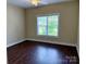 Minimalist bedroom with hardwood floors, a ceiling fan, and a large window overlooking the exterior at 822 Wisteria Way, Salisbury, NC 28146