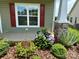 Close-up of a garden bed with flowering bushes in front of the house, along with a community sign at 822 Wisteria Way, Salisbury, NC 28146