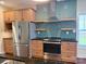 Well-equipped kitchen with stainless steel appliances, attractive backsplash, and wooden cabinets and drawers at 822 Wisteria Way, Salisbury, NC 28146