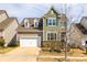 Inviting two-story home featuring a well-manicured lawn, attached garage, and charming architectural details at 844 Braddock Way, Fort Mill, SC 29715