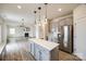 Open concept kitchen with island, stainless appliances, and view of the living room fireplace at 844 Braddock Way, Fort Mill, SC 29715
