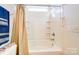 Clean bathroom with a shower-tub combo, shower curtain, and tiled surround at 9741 Turning Wheel Dr, Charlotte, NC 28214