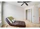 Cozy bedroom featuring a comfortable chaise lounge, ceiling fan, and closet at 9741 Turning Wheel Dr, Charlotte, NC 28214