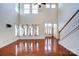 Spacious living room with hardwood floors, tall windows, and staircase at 9741 Turning Wheel Dr, Charlotte, NC 28214