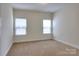 Well-lit bedroom with carpet, neutral paint, and two bright windows with blinds at 1012 Equipoise Dr, Indian Trail, NC 28079